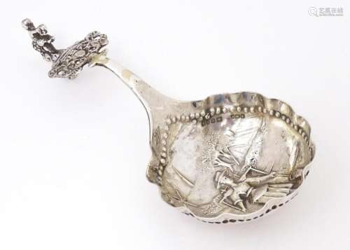A Dutch silver caddy spoon with landscape scene with figure,...