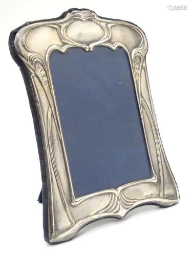 A photograph frame with silver surround having Art Nouveau s...