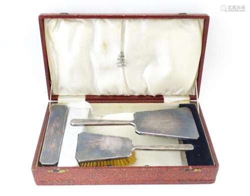 A cased Art Deco dressing table set comprising two silver ha...