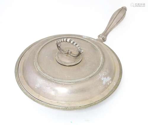 A silver plate lidded warming dish, opening to reveal sectio...