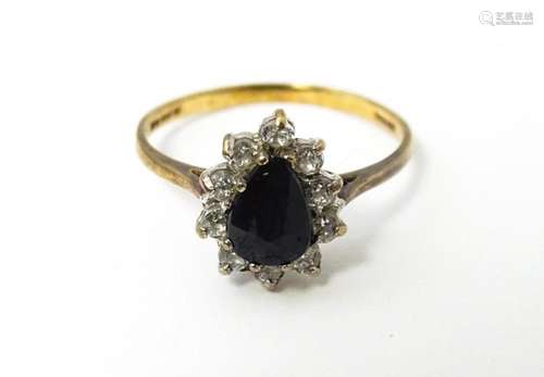 A 9ct gold ring set with central blue stone bordered by whit...