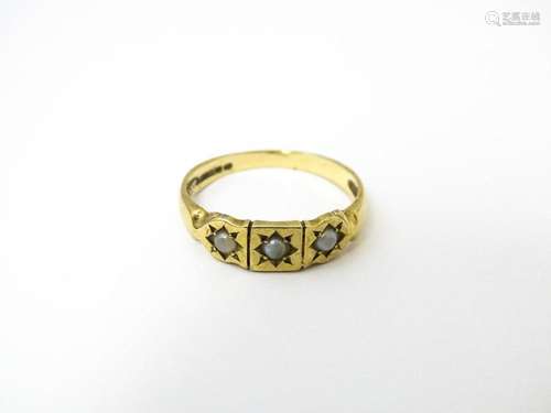 A 9ct gold ring set with three seed pearls. Ring size approx...