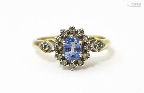 A 9ct gold ring set with central topaz bordered by diamonds ...