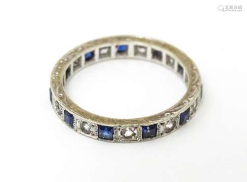 A 9ct gold eternity ring set with sapphires and white stones...