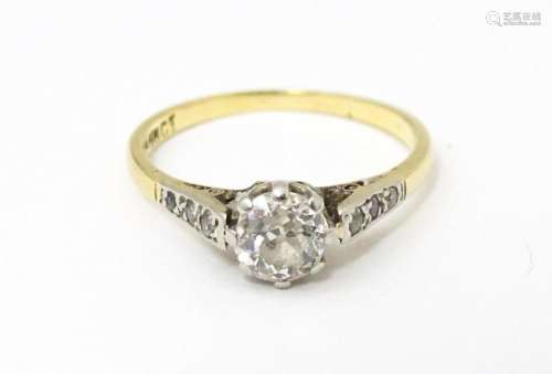 An 18ct gold ring with platinum set central diamond flaked b...