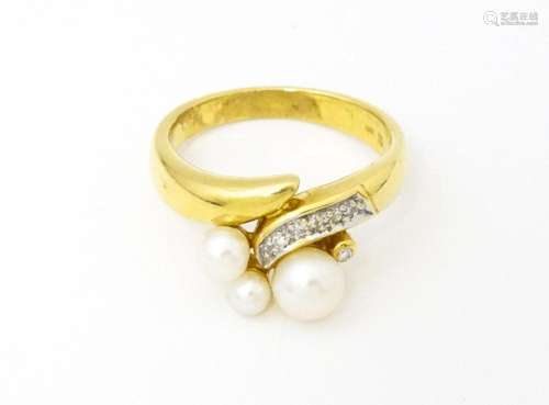 An 18ct gold ring set with diamonds and pearls. Ring size ap...