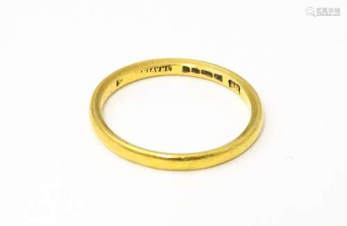 A 22ct gold ring, retailed by Bravingtons. Ring size approx....