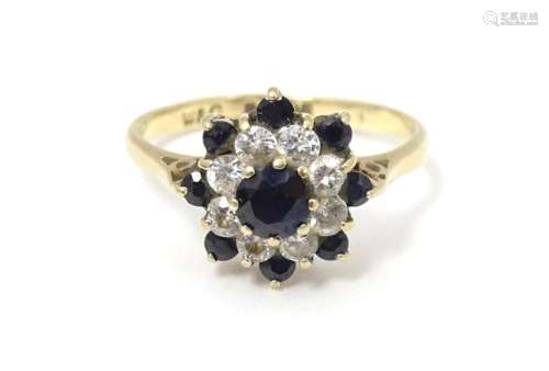 A 9ct gold ring set with sapphires and white stones in a clu...