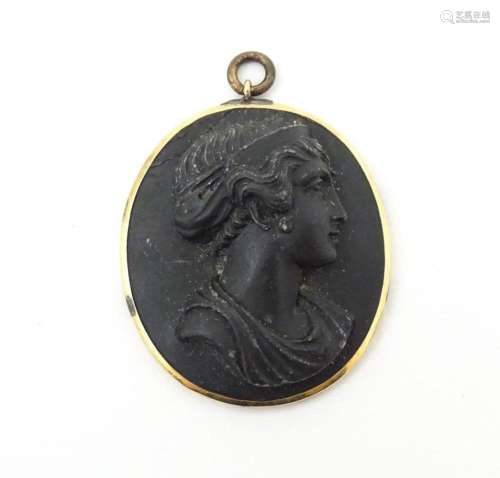 A Victorian black lava cameo pendant in yellow metal mount. ...