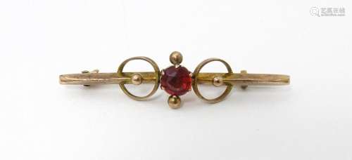 A 9ct gold bar brooch set with red stone. 1 3/4" long