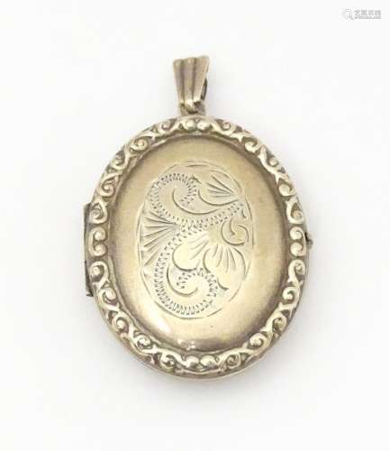 A white metal pendant of locket form with engrave decoration...