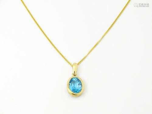 A 9ct gold pendant set with topaz on an 18" long neckla...