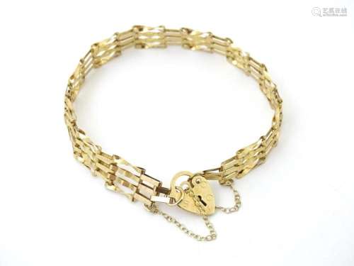 A gold bracelet with padlock formed clasp.
