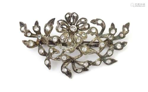 A white metal brooch of floral and foliate form set with pas...
