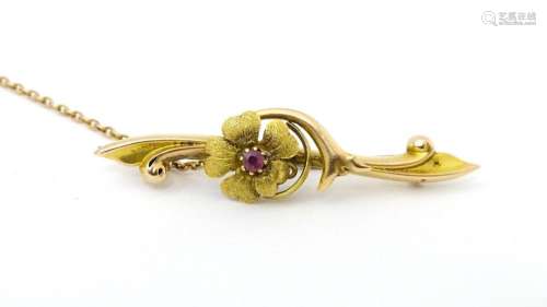 An Art Nouveau 15ct gold bar brooch with floral detail and c...