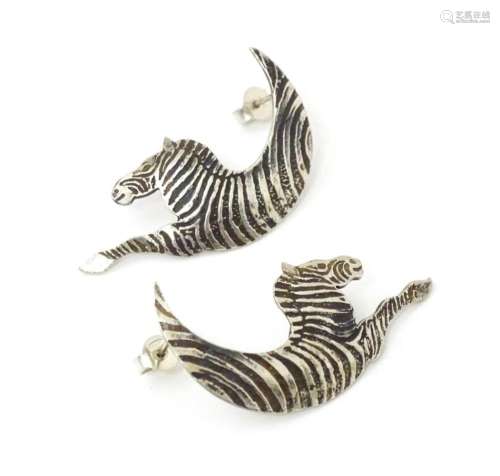 A pair of silver earrings formed as stylized zebras. Hallmar...