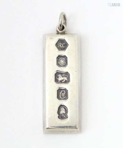 A silver pendant of ingot form hallmarked Sheffield 1977 mak...