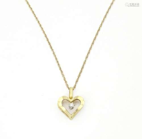 A 9ct gold pendant of heart form set with central diamond, o...