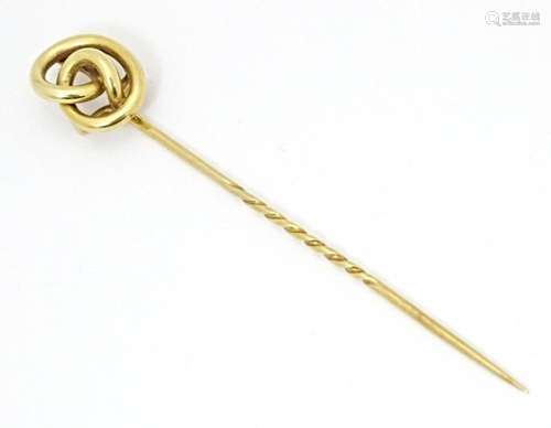 A yellow metal stick pin with knot detail. Approx. 3" l...