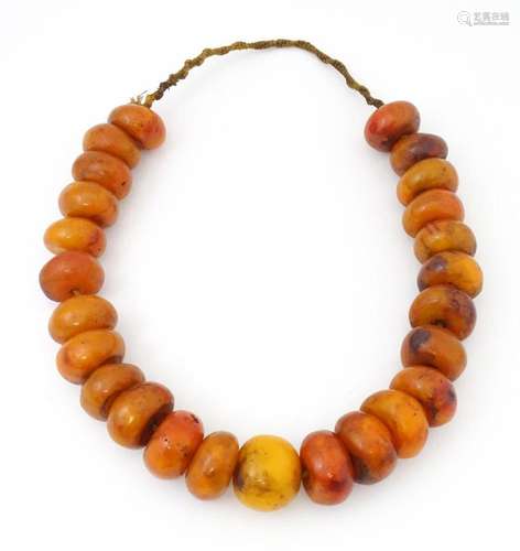 A necklace of large amber coloured beads. Approx 22" lo...