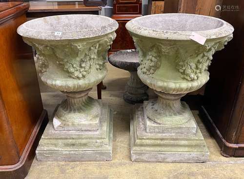 A pair of circular reconstituted campana garden urns with fl...