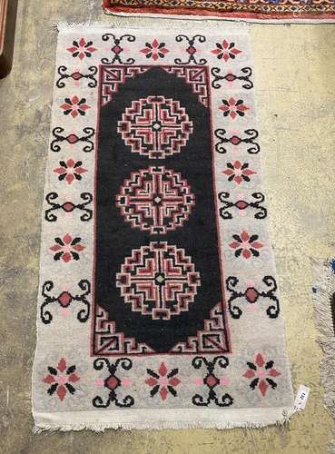 A Tibetan black ground geometric rug, 164cm x 86cm