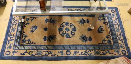 A pair of Chinese beige ground rugs and a similar rug, 174 x...