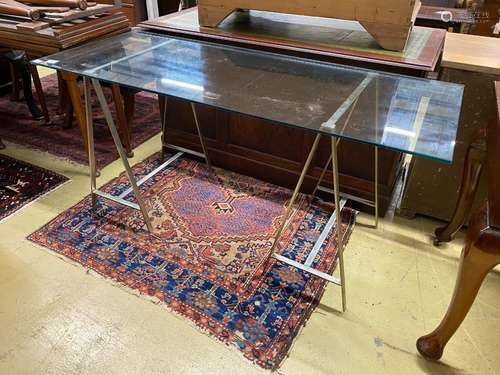 A contemporary rectangular plate glass topped console table,...