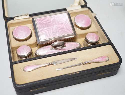 A cased George V nine piece silver and pink enamel mounted m...