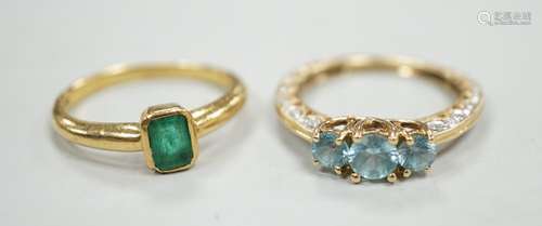 A modern 18ct gold and single stone emerald set ring, size M...