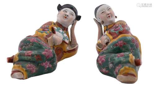 A pair of Chinese porcelain figures of a reclining male and ...