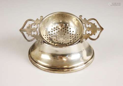 A George VI silver tea strainer and stand, the strainer with...