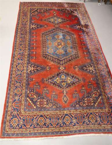 Tapis oriental à fond rouge et motifs géométriques, lon