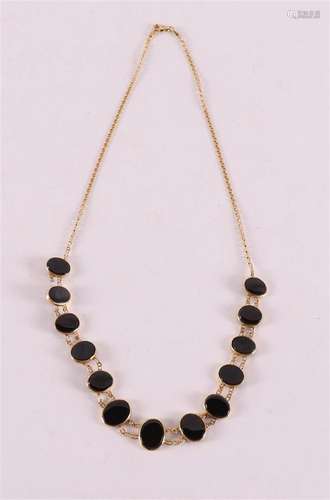 Un collier en or jaune 14 kt 585/1000 avec un onyx oval