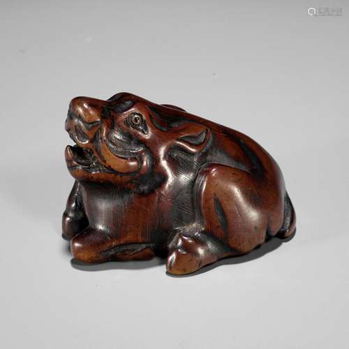 A FINE TANBA SCHOOL WOOD NETSUKE OF A RECUMBENT BOAR