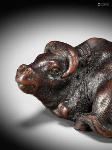 IKKAN: A SUPERB WOOD NETSUKE OF A RECUMBENT OX