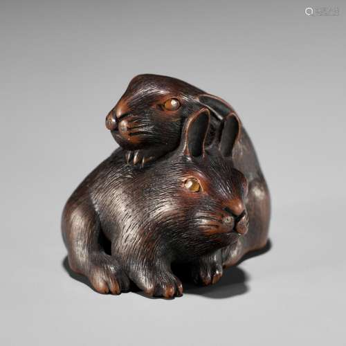 MASATADA: A FINE WOOD NETSUKE OF TWO RABBITS WITH AMBER EYES