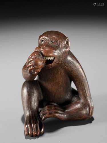 MASANAO: A WOOD NETSUKE OF A MONKEY EATING A PERSIMMON