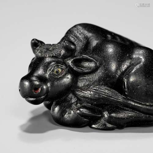 【†】 MINKO: AN EXQUISITE EBONY WOOD NETSUKE OF A RECUMBENT OX