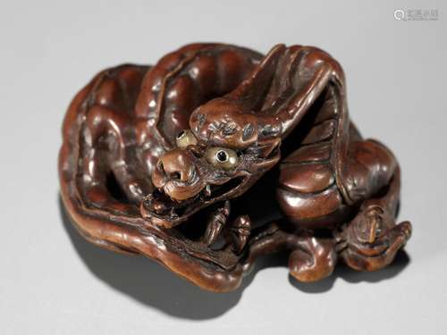 HIDARI ISSAN: A SUPERB WOOD NETSUKE OF A COILED DRAGON