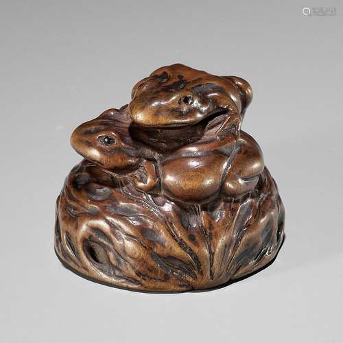 【†】 ISSAN: A WOOD NETSUKE OF TWO TOADS ON A WALNUT