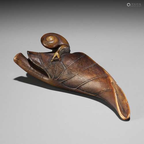 【†】 KANMAN: A RARE BUFFALO HORN NETSUKE OF A SNAIL ON A TARO...