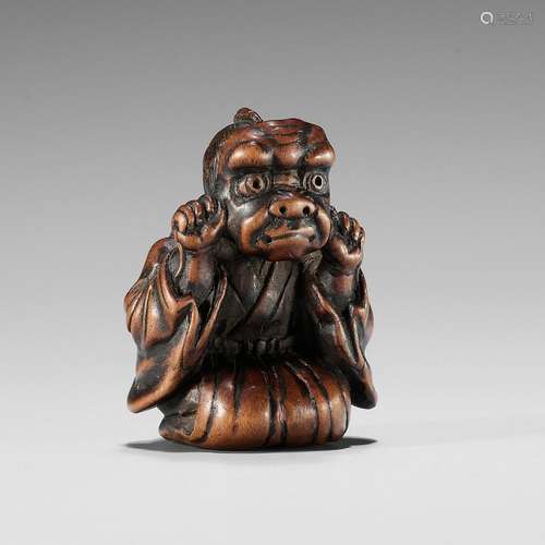 A FINE EDO SCHOOL WOOD NETSUKE OF A BOY WEARING AN ONI MASK