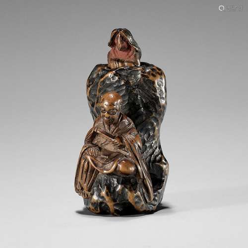 A RARE AND UNUSUAL TRICK WOOD NETSUKE OF A RAKAN AND FOX