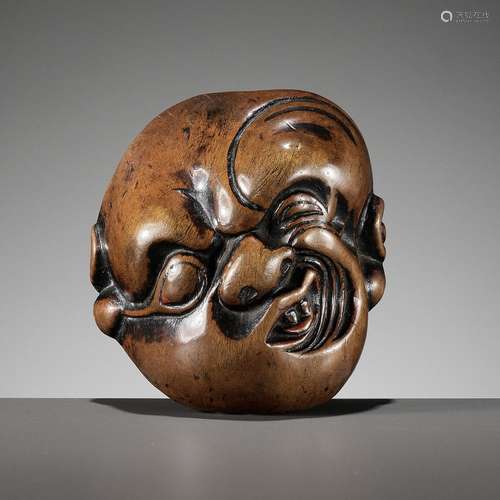 AN IMPORTANT EARLY WOOD MASK NETSUKE DEPICTING A GRIMACING M...