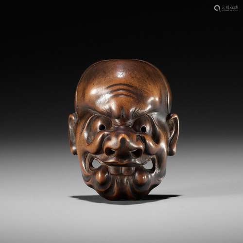 KOKEISAI SANSHO: A SUPERB STAINED WOOD MASK NETSUKE OF A GHO...