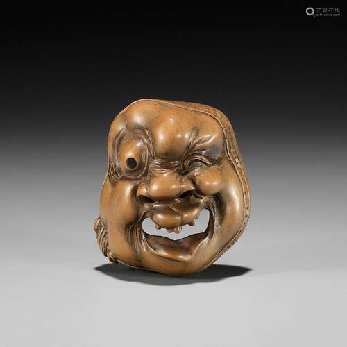 KOKEISAI SANSHO: A SUPERB WOOD MASK NETSUKE OF A GROTESQUELY...