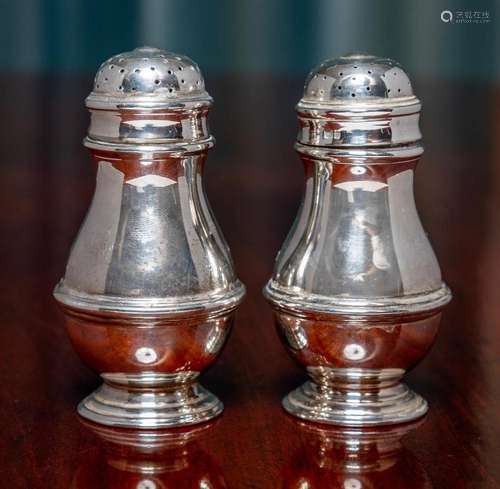 A pair of Queen Anne style sterling-silver pepperettes, make...