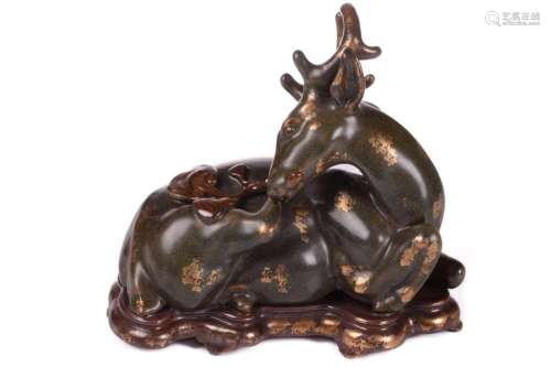 A Chinese porcelain simulated bronze figure of a recumbent s...