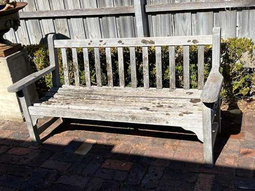 A slatted-teak garden seat with makers label 160cm wide 84cm...